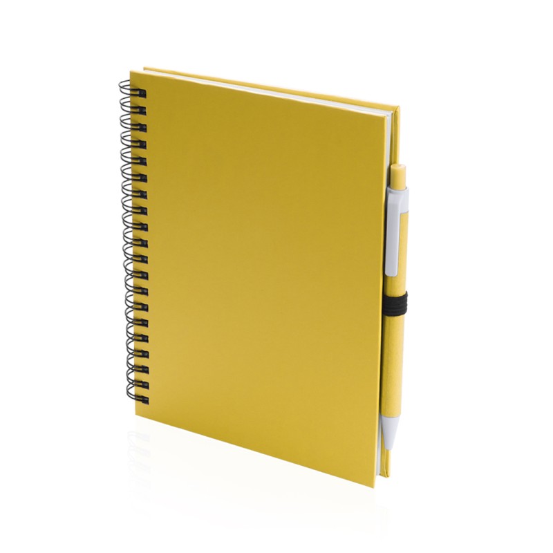 Libreta A5 de anillas con tapas decartón reciclado. 70 hojas y bolígrafo incluido. Medidas: 15 x 18,2 cm. Marcaje: Serigrafía 1