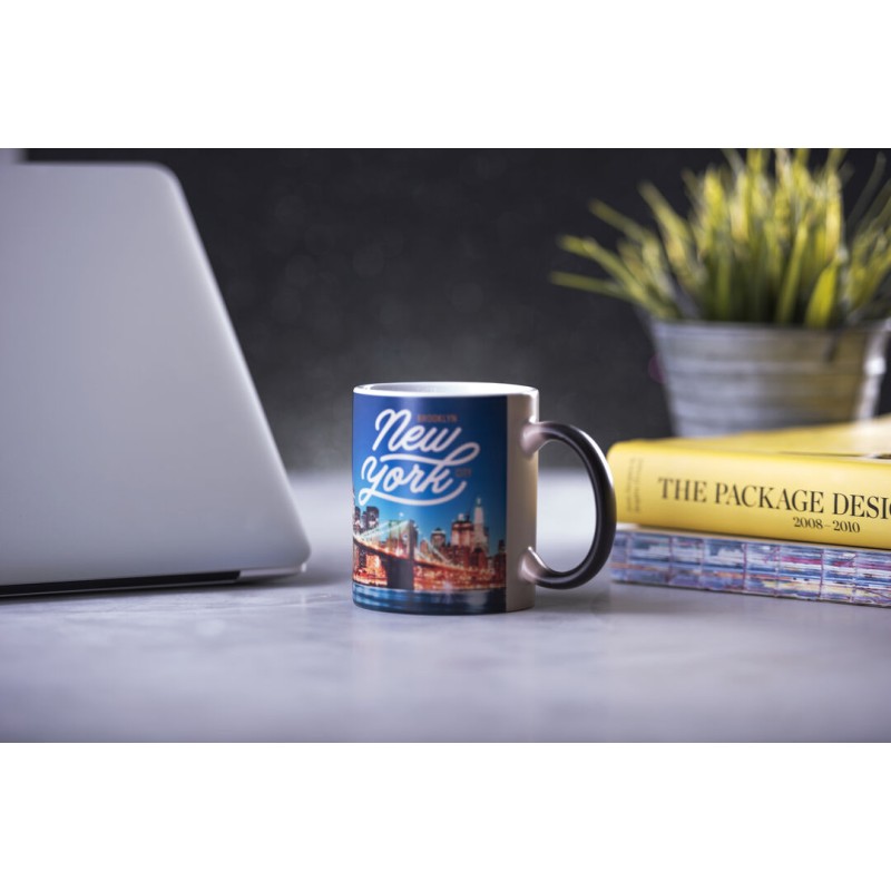 Taza sublimada con una fotografía nocturna de Nueva York a todo color junto a un portátil