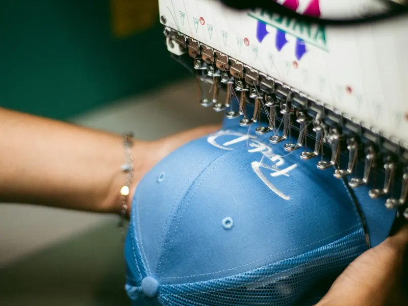 Máquina de bordar cosiendo un logotipo en una gorra